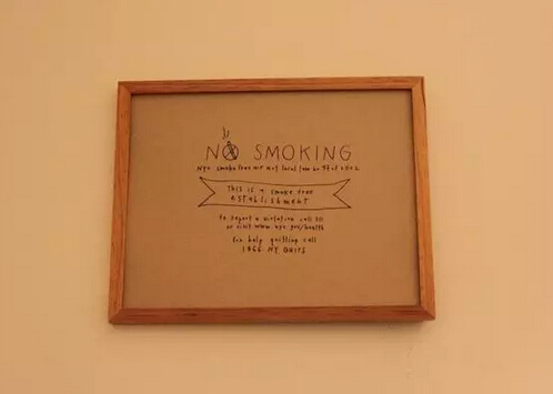 咖啡厅内小而简洁的手写体告示板——禁止吸烟（如果想离开，上面还提供可以吸烟的门店门牌号码）。